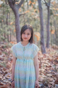 Portrait of beautiful young woman standing in forest