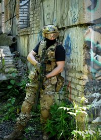 Soldier with machine gun hiding behind wall