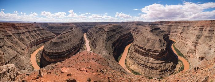 Panoramic view of rocky mountains at goosenecks state park against cloudy sky