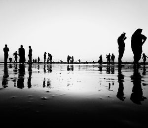 Silhouette people walking on beach