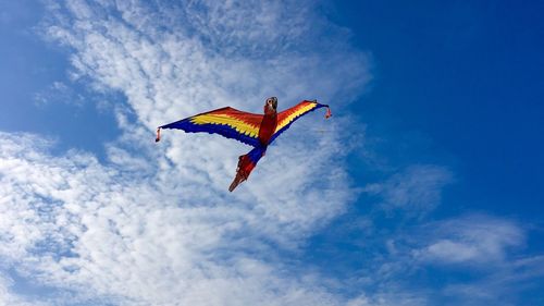 Low angle view of multi colored kite flying against sky