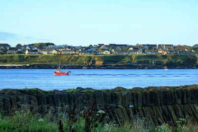 Boats in river with buildings in background