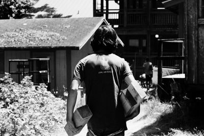 Rear view of woman standing in front of building