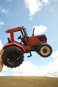 Low angle view of traditional machinery on field against sky