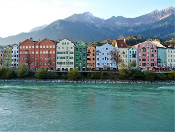 Buildings by sea against mountains