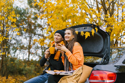 A happy young family is relaxing after a day spent outdoors in the autumn forest. a couple in love 