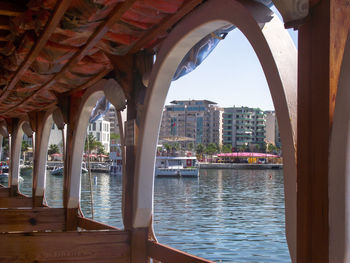 Buildings by river against sky in city