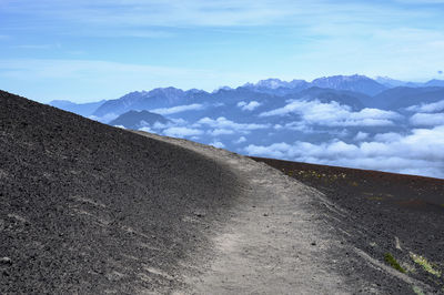 Road by mountains against sky