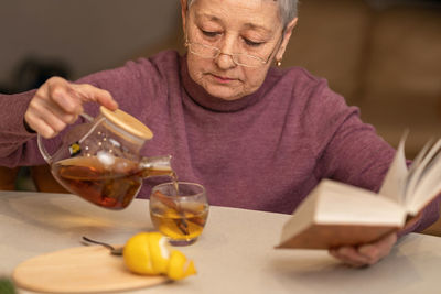 Senior woman pouring tee in cup