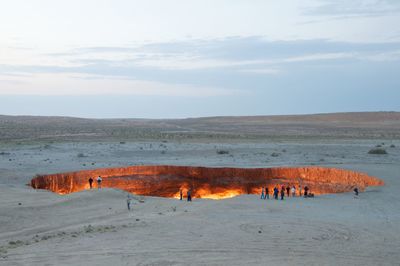 People at field by door to hell