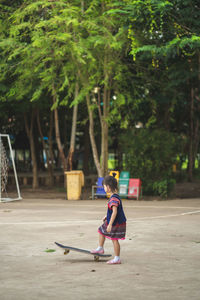 Side view of girl standing on skateboard