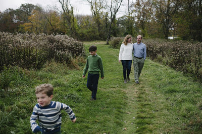 High angle view of family walking on grassy field at park