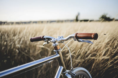 Bicycle on golden field against sky during sunset