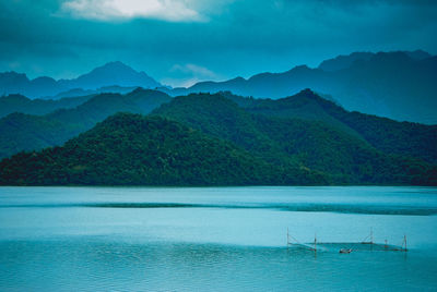 Scenic view of sea and mountains against sky