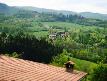 Scenic view of agricultural landscape and houses against mountain