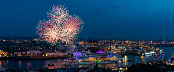 Firework display over river at night