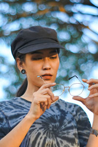 Woman with eyeglasses wearing cap at park
