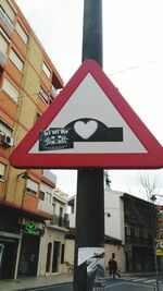 Close-up of road sign against sky