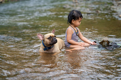 Girl with dog in river