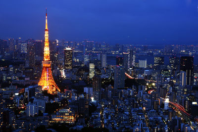 Tokyo tower amidst illuminated cityscape at night