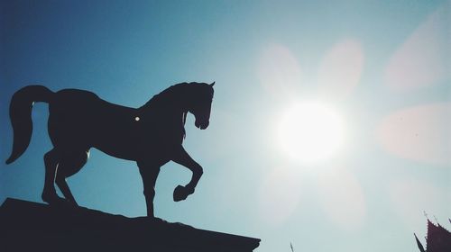 Low angle view of silhouette statue against sky