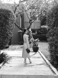 Woman with umbrella standing by plants