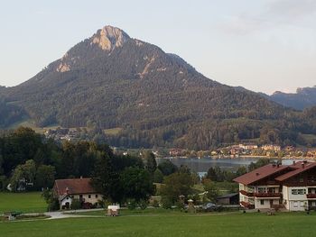 Houses by trees and mountains against sky