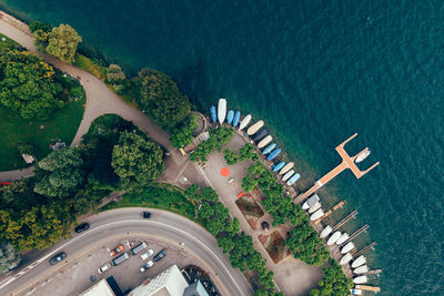 Lugano city park entrance with boats and the lake of ticino and trees and flowers taken with a drone