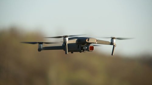 Low angle view of drone flying against sky