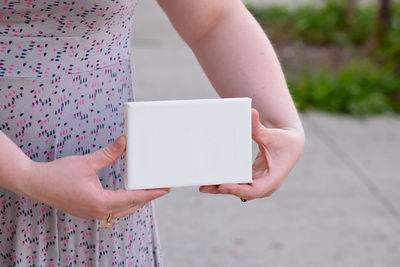 Midsection of woman holding blank sign