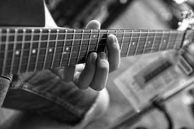 Midsection of man playing guitar