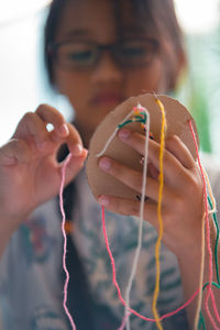 Close-up of girl making multi colored decoration