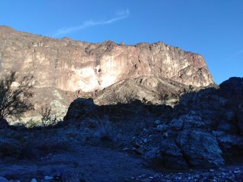 Scenic view of rocky mountains against blue sky
