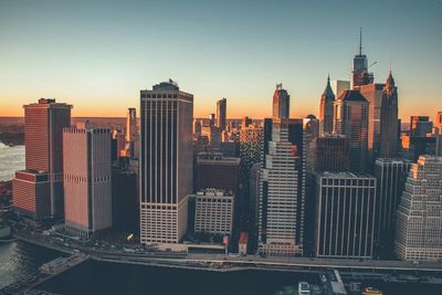 Skyscrapers in city at sunset