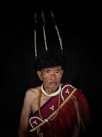 Portrait of man wearing hat against black background