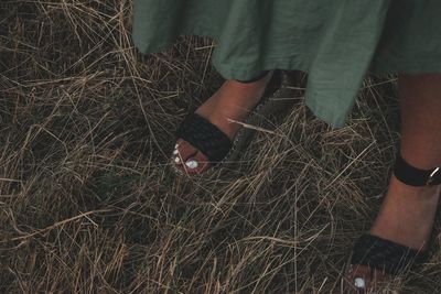 Low section of woman standing on field