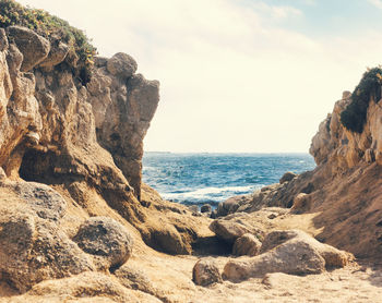 Scenic view of rocks on beach against sky