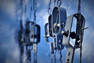 Close-up of metal hanging against sky