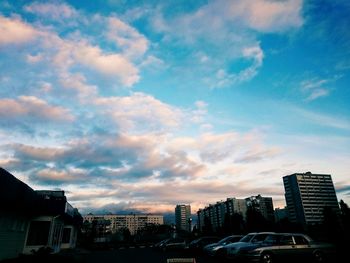 Buildings in city against cloudy sky