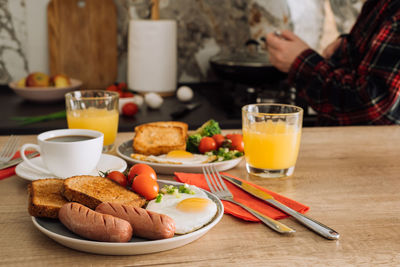 Cooked english breakfast with coffee and orange juice in the kitchen at home	
