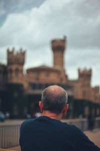 Rear view of man in city against sky