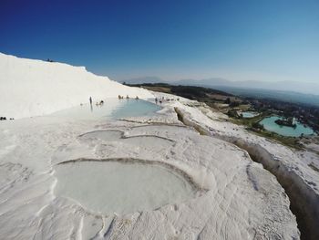 View of hot spring against clear blue sky