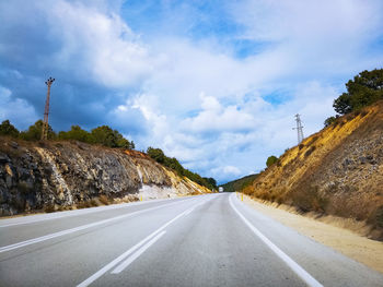 Empty road by mountain against sky