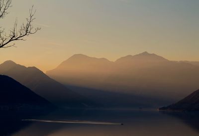 Scenic view of lake against mountains during sunset