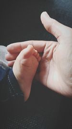 Close-up of baby hand against black background