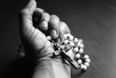 Close-up of hand holding rosary beads