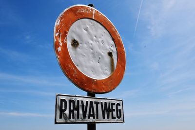 Low angle view of road sign against sky