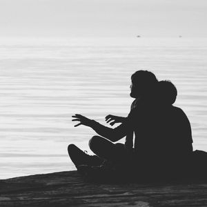 Rear view of woman sitting on bench