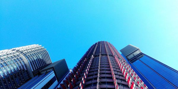 Low angle view of modern buildings against clear blue sky