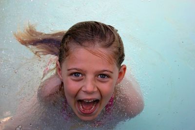 Portrait of happy girl playing in swimming pool